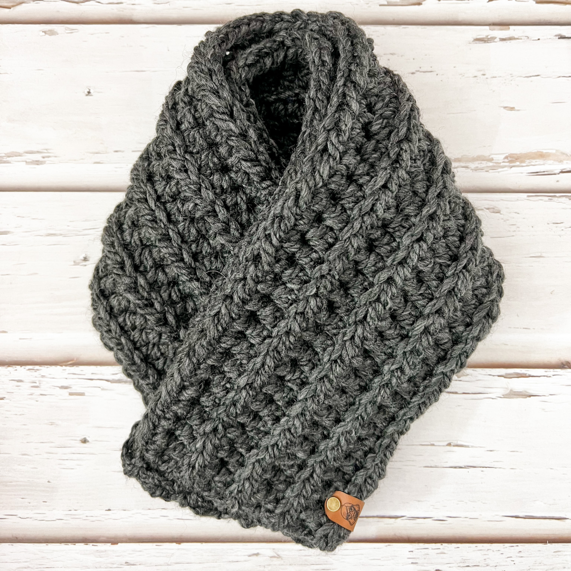 Our infinity scarf in the colour charcoal displayed on wooden slats