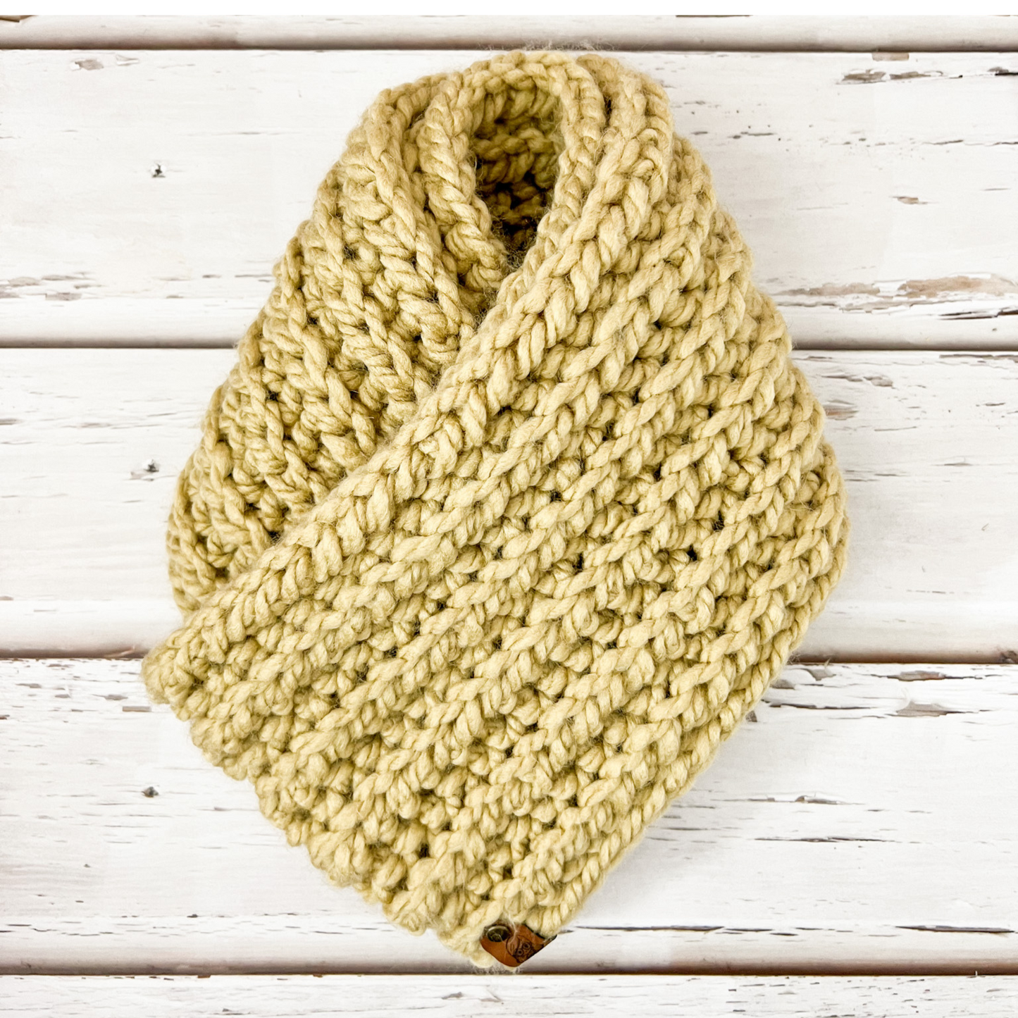 Our infinity scarf in the colour peanut displayed on wooden slats