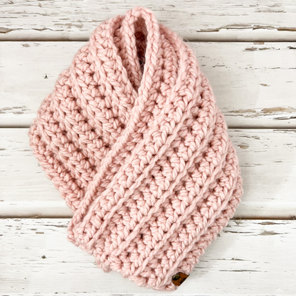 Our crochet infinity scarf in the colour pdisplayed on wooden slatsnk 